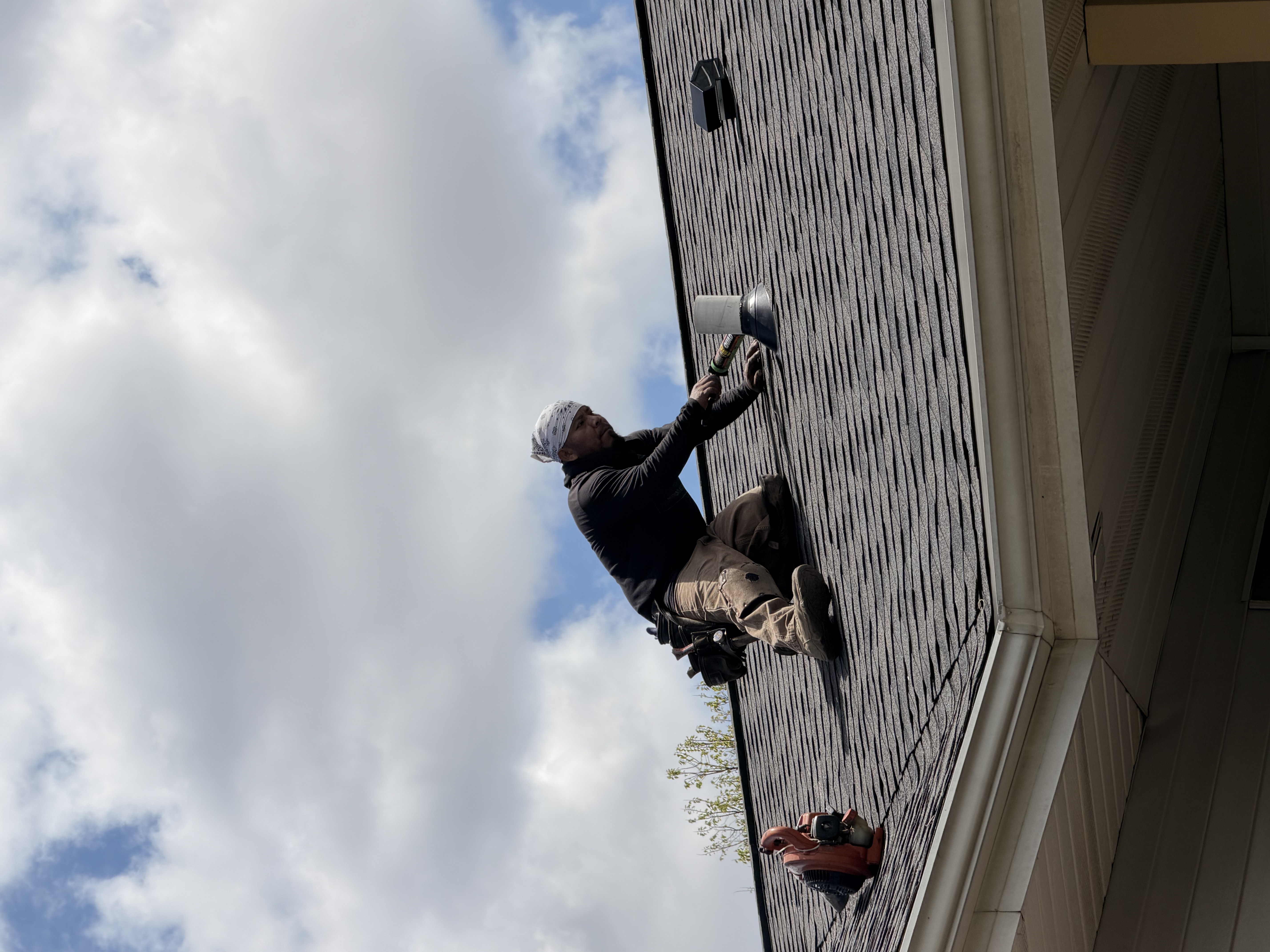 Professional roofer installing shingles on a residential home